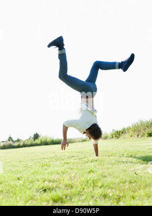 Man doing handstand on grass Stock Photo