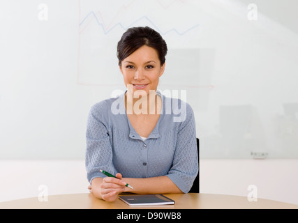 Portrait of smiling businesswoman sitting in office Stock Photo