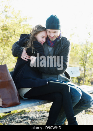 Young couple relaxing on park bench Stock Photo