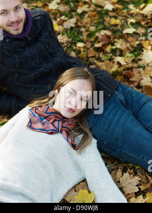 Portrait of young couple lying in leaves Stock Photo