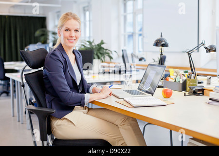 Portrait of businesswoman using laptop in office Stock Photo