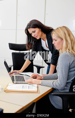 Two female colleagues working together in office environment Stock Photo