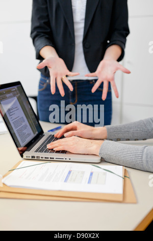 Two female colleagues working together in office environment Stock Photo