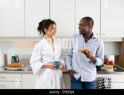 Couple embracing in kitchen in morning Stock Photo