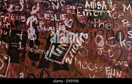 Writing on the Wall - Random words and phrases are scrawled across a wall of an old building. Stock Photo