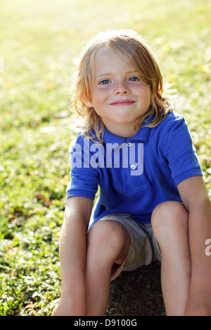 Portrait of boy sitting on grass Stock Photo