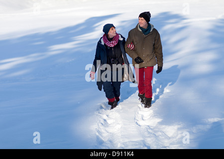 Couple walking in snow Stock Photo