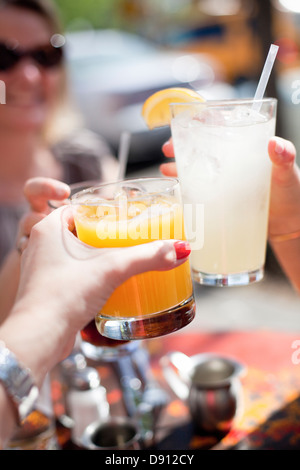 Womens hands holding cocktails Stock Photo
