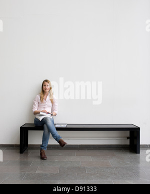 Young student sitting on bench Stock Photo