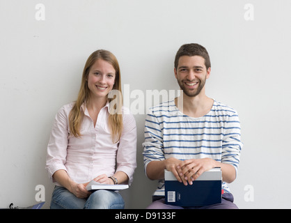 Young students sitting on bench Stock Photo