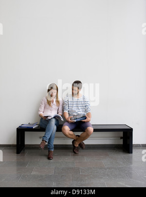 Young students sitting on bench Stock Photo