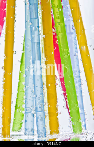 Colorful drinking straws in glass of water