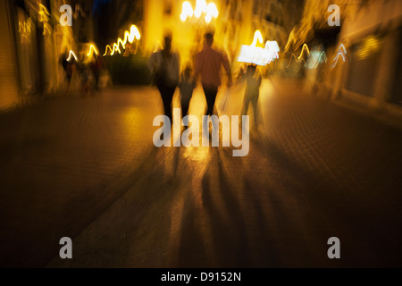 Family walking on street at night Stock Photo