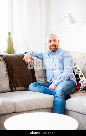 Man sitting on sofa Stock Photo