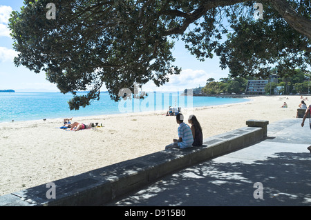 dh North island beaches AUCKLAND MISSION BAY NEW ZEALAND NZ Couple sitting on prome wall overlooking sandy beach nz people Stock Photo