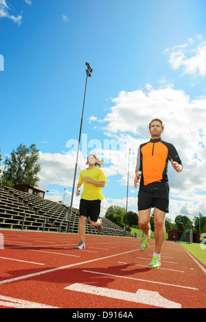 Two men running on stadium Stock Photo