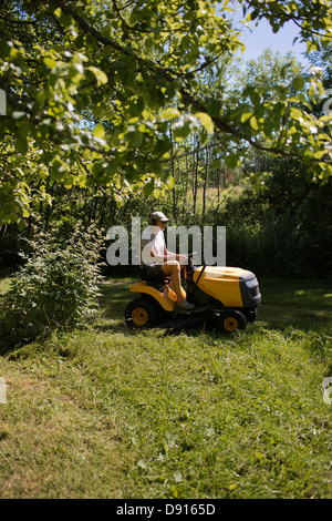 Mature man on riding-on lawn mower Stock Photo