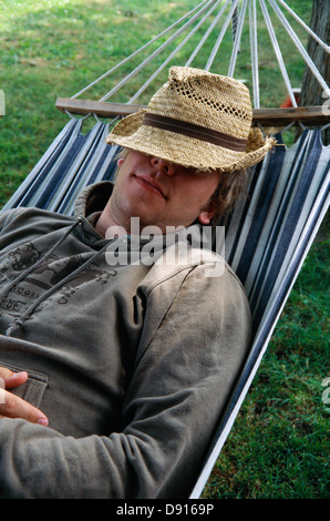 A man lying in a hammock, Skane, Sweden. Stock Photo