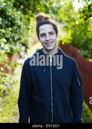 Portrait of young man standing on footpath Stock Photo