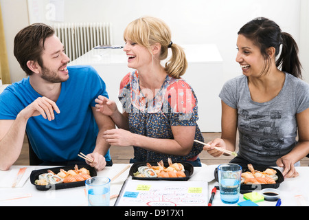 Colleagues in an office having sushi for lunch, Sweden. Stock Photo