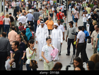 Arab men in a crowd of tourists, Dubai, United Arab Emirates Stock Photo