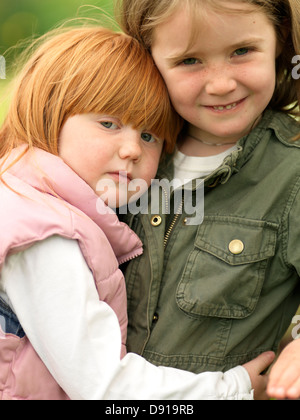 Portrait of two girls hugging outdoors Stock Photo - Alamy