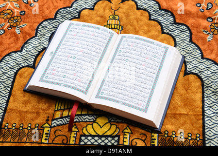 Koran, Quran, Qur'an, Holy Koran book, Quran religious text, Islamic literature Koran on a prayer rug Stock Photo