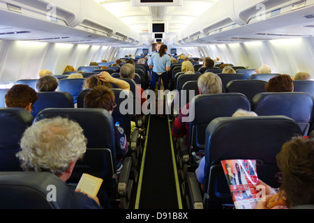 Passengers on a aeroplane, interior of seating area on aircraft, passengers in economy seats during flight Stock Photo