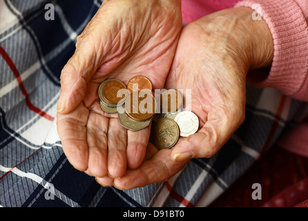 Money, coins in an elderly woman's hands, close up of cash in hands of older woman Stock Photo