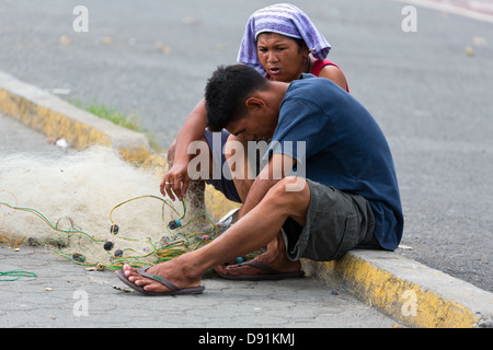 Fisherman preparing his Net on the Bay Walk in Manila, Philippines Stock Photo