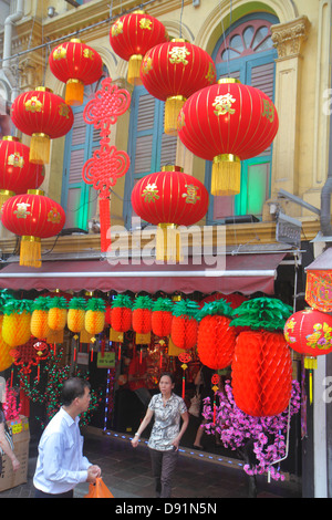 Singapore,Chinatown,Chinese New Year,decorations,ornaments,for sale,front,entrance,Asian man men male,woman female women,shophouse,shopping shopper sh Stock Photo