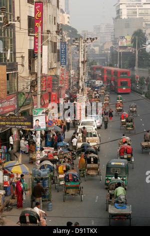 Rickshaw and bus traffic on the street of Dhaka, Bangladesh Stock Photo