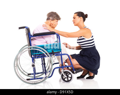 young woman comforting disabled senior mother on white Stock Photo