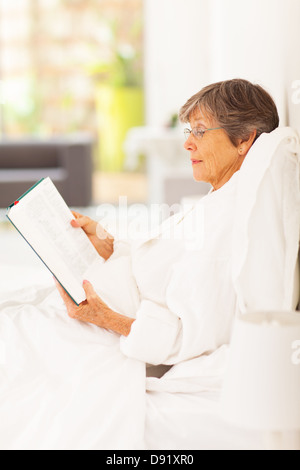 Senior woman reading a book while lying in a hammock Stock Photo - Alamy