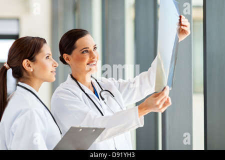 two female medical workers looking at patient's x-ray film Stock Photo