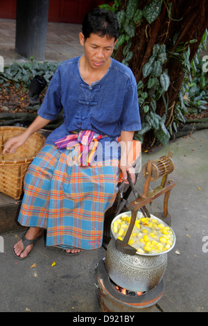 Bangkok Thailand,Thai,Pathum Wan,Jim Thompson House,museum,raw silk,cocoon,yellow,Asian woman female women,boiling,Thai130214008 Stock Photo