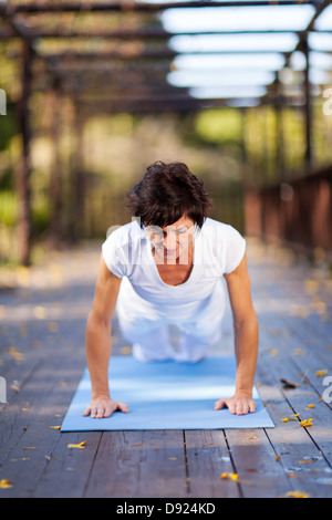 mature woman doing push ups outdoors Stock Photo