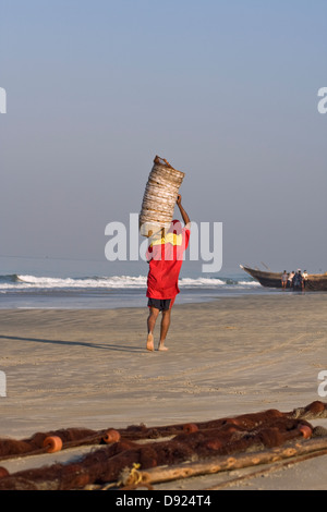 Asia, India, Goa, Benaulim, a fisherman carries empty  fish baskets on his shoulder Stock Photo