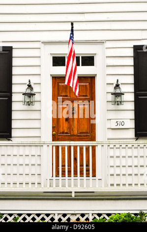 brown wooden door with a US flag in a white wooden wall Stock Photo