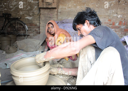 An Indian potter and his wife making flower pots at the potters colony, Delhi, India. Stock Photo