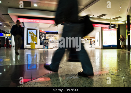 blurred motion of human figures against a background of neon signs unrecognizable stores Stock Photo