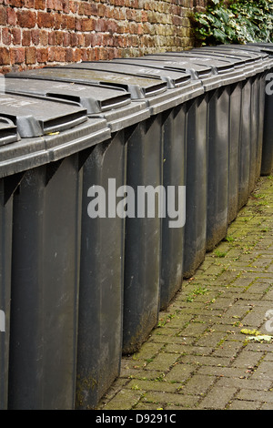 Row of gray wheelie bins used for the storage of domestic rubbish or household garbage disposal Stock Photo