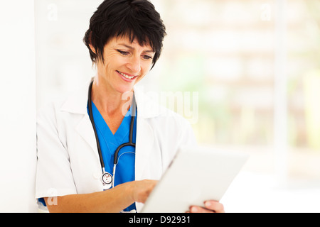 pretty female middle aged healthcare worker using tablet computer Stock Photo