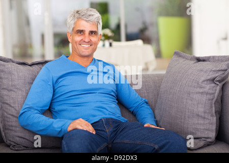 cheerful middle aged man relaxing on sofa at home Stock Photo