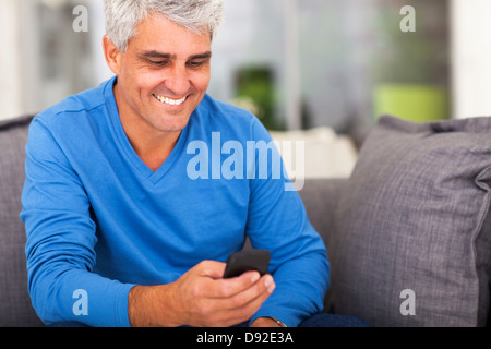 cheerful middle aged man reading emails on smart phone Stock Photo