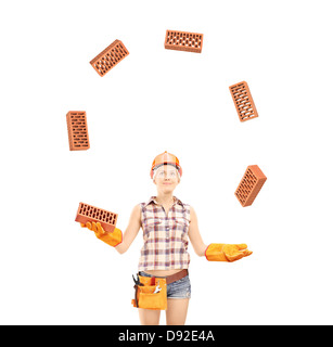 Female construction worker juggling bricks isolated on white background Stock Photo