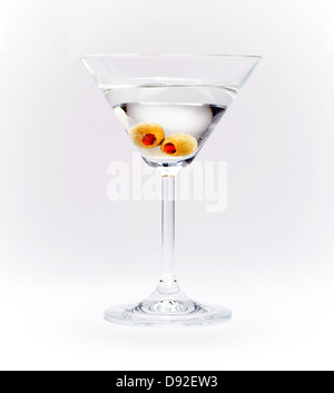 Closeup of Martini cocktail with olives on white - grey background