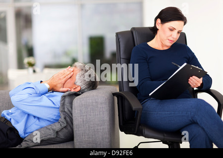 middle aged man crying during session with therapist in office Stock Photo