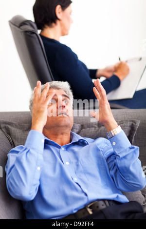 mature middle aged man explaining his problem to psychologist Stock Photo