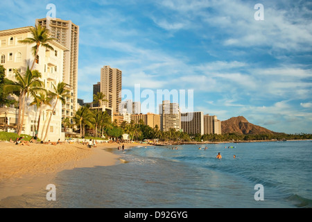 Tourist sunbathing and surfing on Waikiki beach in Oahu Stock Photo